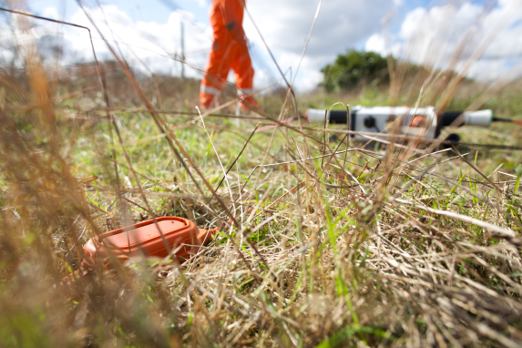 508XT far away on grass with worker on field environment